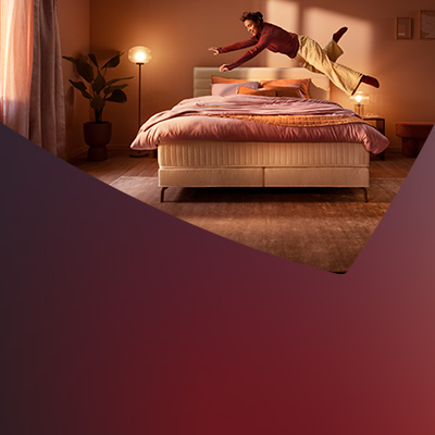 Frau springt auf Boxspringbett Royal Horizon.